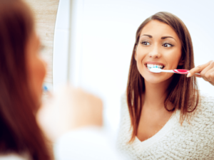 femeie care se spala pe dinti cu periuta de dinti