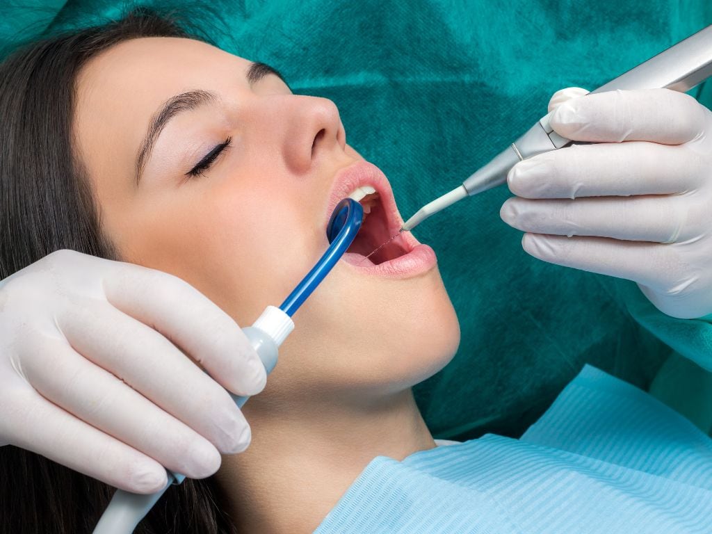 femeie la medicul stomatolog care are parte de tratamente de profilaxie dentara