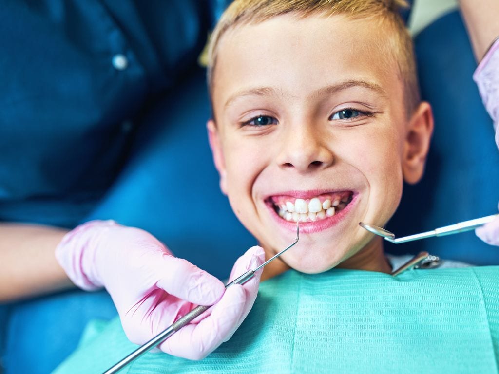 copil care zambeste in timpul unui control stomatologic